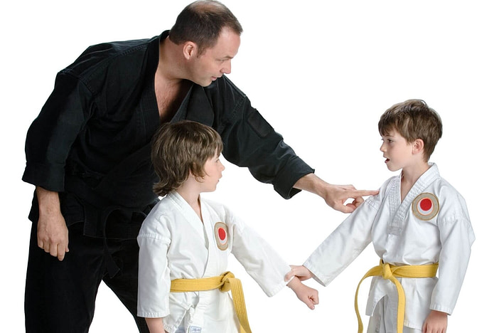 Martial arts instructor training two kids